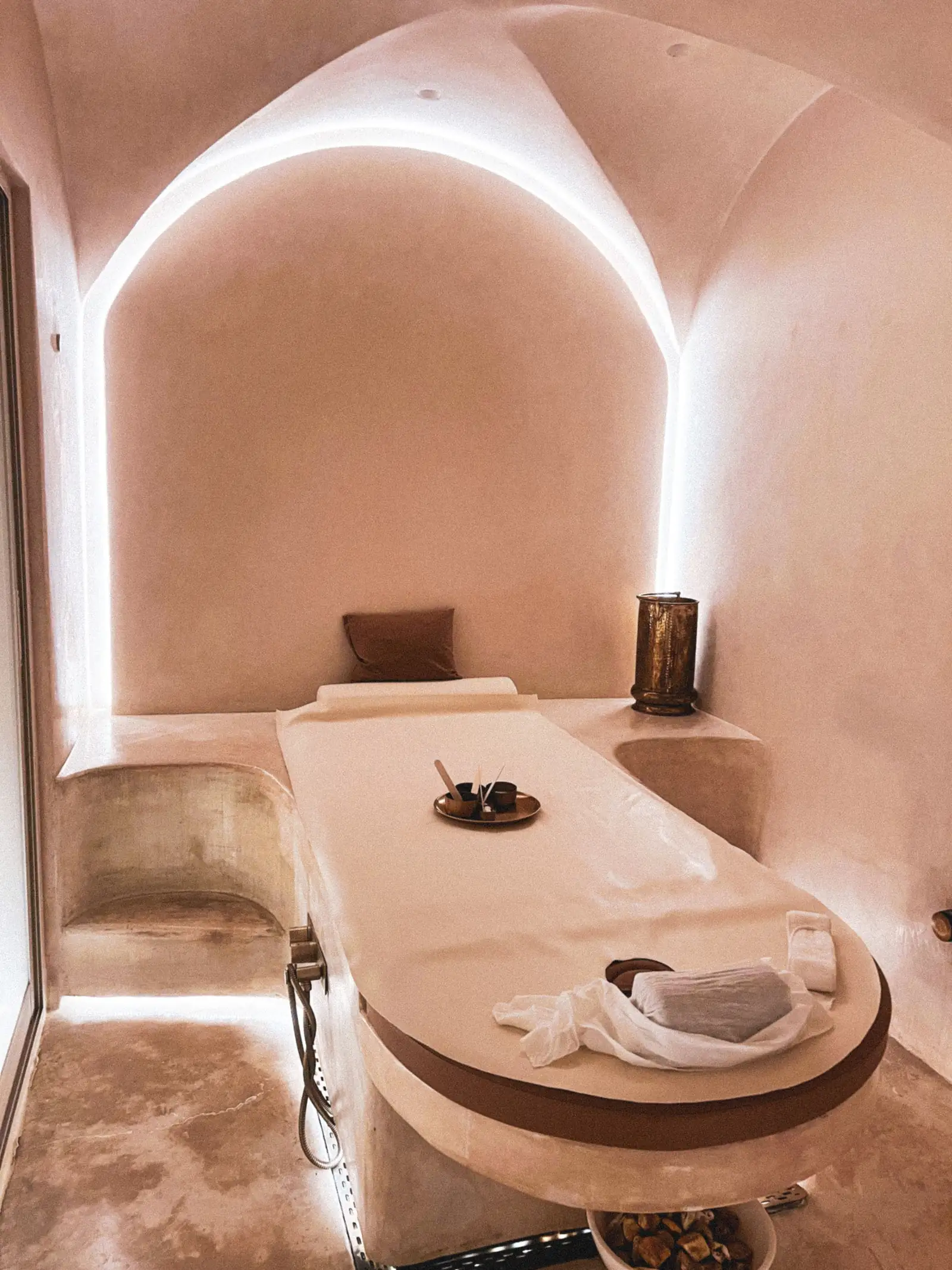 Sala de masaje serena, con camilla, luz cálida y toallas dobladas